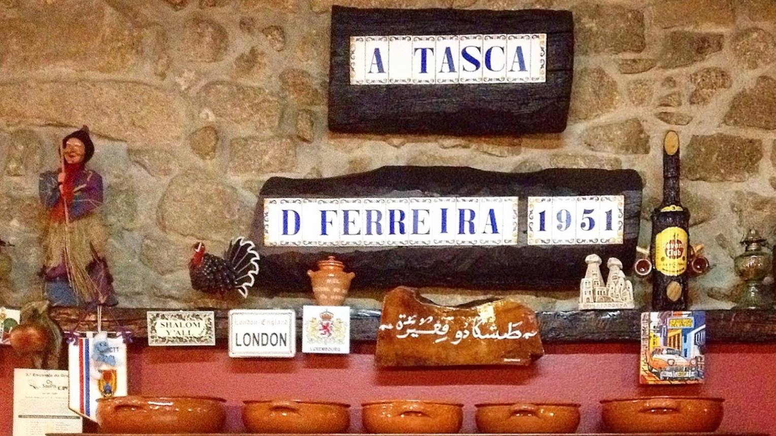 Parede de pedra com a placa em azulejo A Tasca D. Ferreira 1951