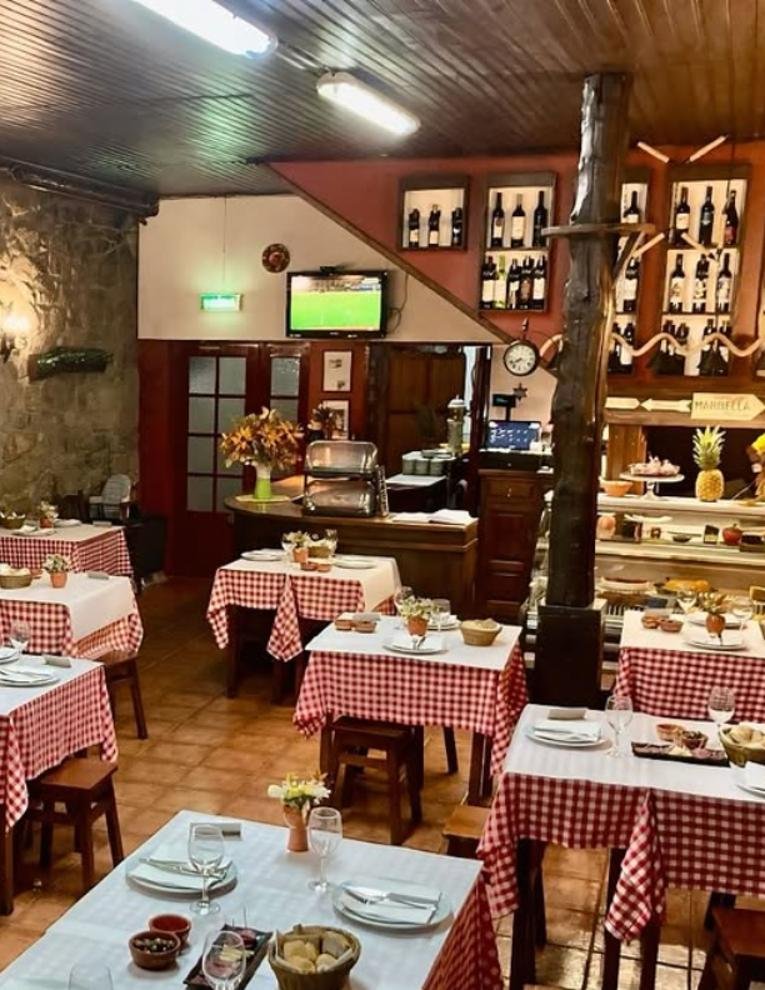 Sala da Tasquinha com mesas de toalha aos quadrados e o balcão
